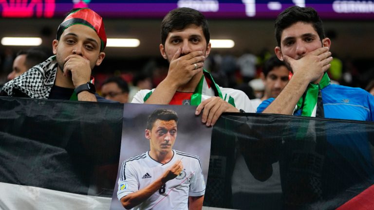Spectators hold photo of Forman German international Mesut Ozil on the stands at the end of the World Cup group E soccer match between Spain and Germany, at the Al Bayt Stadium in Al Khor , Qatar, Monday, Nov. 28, 2022. (Julio Cortez/AP)