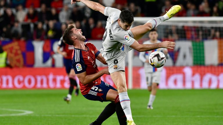 Osasuna's David Garcia, left, challenges for the ball with Barcelona's Robert Lewandowski during a Spanish La Liga soccer match between Osasuna and Barcelona at El Sadar stadium in Pamplona, Spain, Tuesday, Nov. 8, 2022. (Alvaro Barrientos/AP)