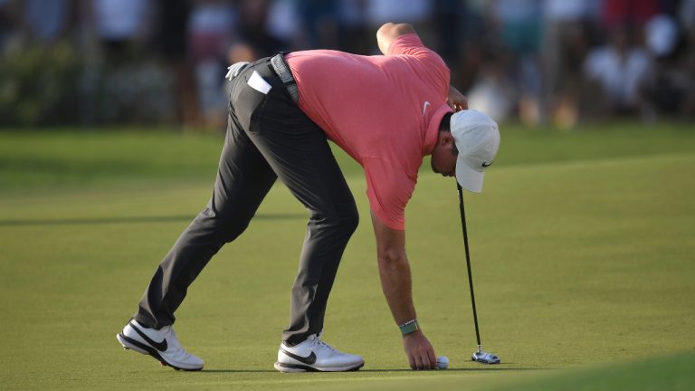 ory McIlroy of Northern Ireland places the ball on the 18th green during DP World Tour Championship in Dubai, United Arab Emirates, Saturday, Nov. 19, 2022. (Martin Dokoupil/AP)