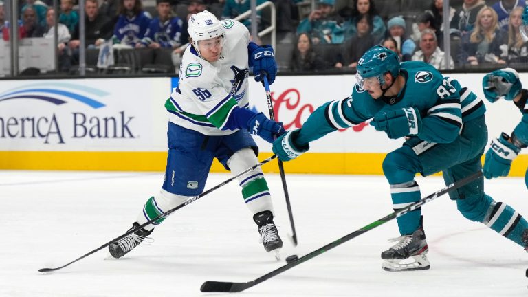 Vancouver Canucks left wing Andrei Kuzmenko (96) takes a shot at goal past San Jose Sharks left wing Matt Nieto (83) during the first period of an NHL hockey game, Sunday, Nov. 27, 2022, in San Jose, Calif. (Tony Avelar/AP)