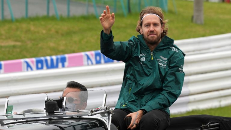Aston Martin driver Sebastian Vettel of Germany waves during the drivers parade ahead of the Japanese Formula One Grand Prix at the Suzuka Circuit in Suzuka, central Japan, Sunday, Oct. 9, 2022. (Eugene Hoshiko/AP)