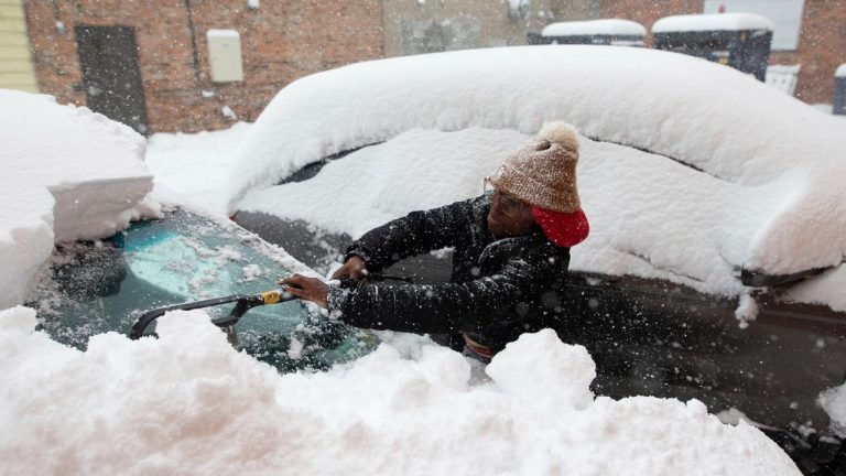 Zaria Black, 24, from Buffalo, clears off her car as snow falls Friday, Nov. 18, 2022, in Buffalo, N.Y. A dangerous lake-effect snowstorm paralyzed parts of western and northern New York, with nearly 2 feet of snow already on the ground in some places and possibly much more on the way. (Joshua Bessex/AP Photo)