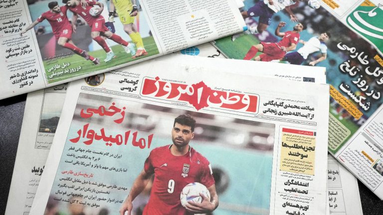The front page of the hard-line Iranian newspaper, Vatan-e Emrooz, bottom, with a headline reading in Farsi: "Wounded, but hopeful," shows Iranian soccer player Mehdi Taremi during the match on Monday with England in the World Cup in Qatar which Iran lost 6-2, in downtown Tehran, Iran, Tuesday, Nov. 22, 2022. Iran is playing at the World Cup as it is being rocked by monthslong protests following the Sept. 16 death of a 22-year-old woman who had been earlier arrested by the country's morality police. (Vahid Salemi/AP) 