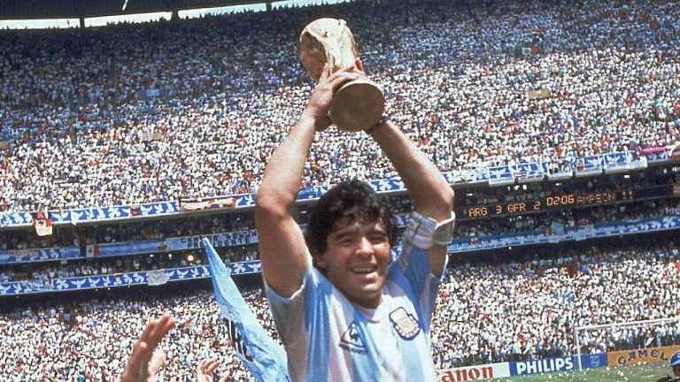 In this June 29, 1986 file photo, Diego Maradona holds up the trophy after Argentina defeated West Germany 3-2 during a World Cup soccer final match at Atzeca Stadium in Mexico City. The Argentine soccer legend says he favors the use of video referees, but appreciates the technology didn't exist in 1986 when he made his famous goal against England using his hand that became known as "The Hand of God." (AP Photo/Carlo Fumagalli, File)