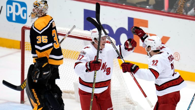 Carolina Hurricanes' Brett Pesce (22) celebrates his game-winning OT goal with Andrei Svechnikov as Pittsburgh Penguins goaltender Tristan Jarry heads for the locker room after an NHL hockey game in Pittsburgh, Tuesday, Nov. 29, 2022.  (Gene J. Puskar/AP Photo)
