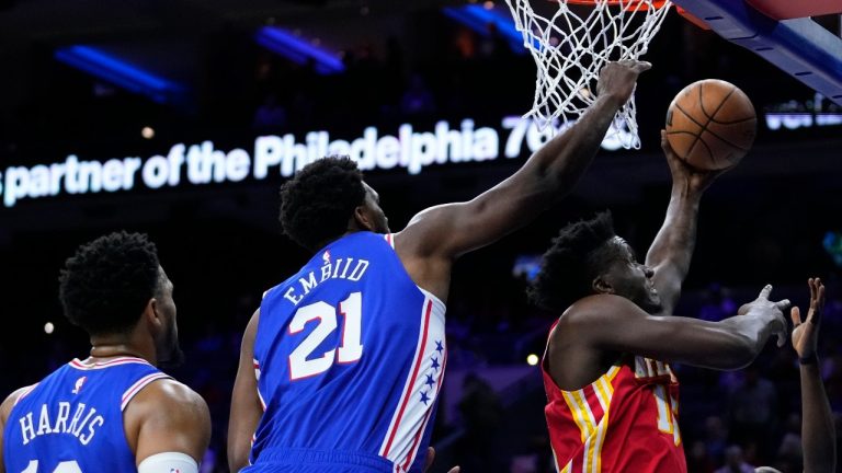 Atlanta Hawks' Clint Capela (15) goes up for a shot against Philadelphia 76ers' Shake Milton (18), Joel Embiid (21) and Tobias Harris (12) during the first half of an NBA basketball game, Monday, Nov. 28, 2022, in Philadelphia. (AP Photo/Matt Slocum)