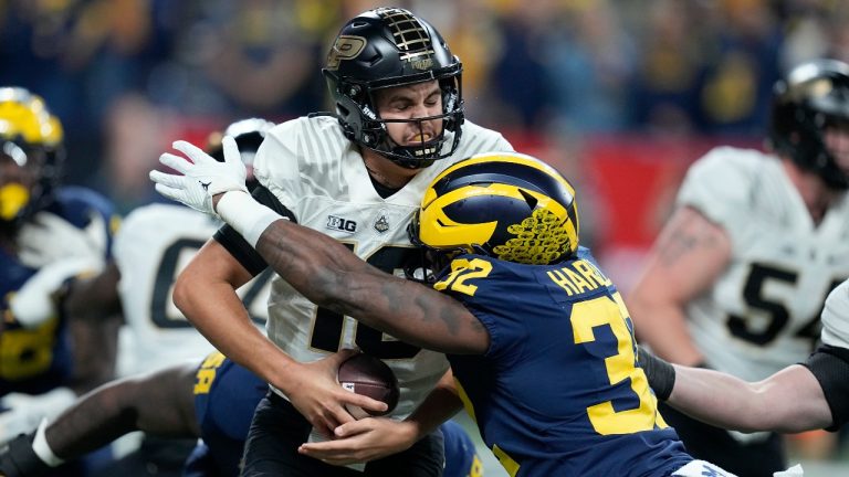 Purdue quarterback Aidan O'Connell, left, is sacked by Michigan linebacker Jaylen Harrell (32) during the first half of the Big Ten championship NCAA college football game, Saturday, Dec. 3, 2022, in Indianapolis. (Darron Cummings/AP Photo)