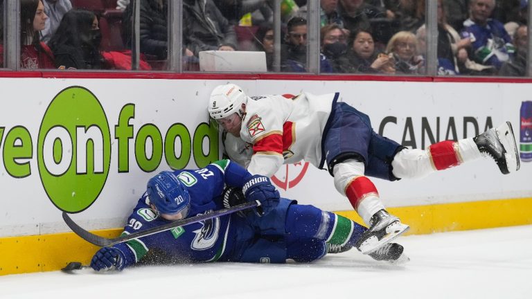 Florida Panthers' Sam Bennett (9) checks Vancouver Canucks' Curtis Lazar (20) during the first period of an NHL hockey game in Vancouver, on Thursday, December 1, 2022. (Darryl Dyck/THE CANADIAN PRESS)