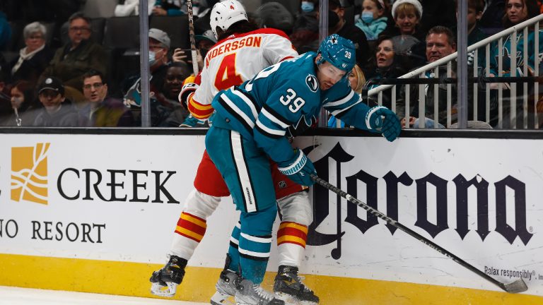 Calgary Flames defenseman Rasmus Andersson (4) battles for the puck against San Jose Sharks center Logan Couture (39) in the first period of an NHL hockey game, Tuesday, Dec. 20, 2022, in San Jose, Calif. (Josie Lepe/AP)