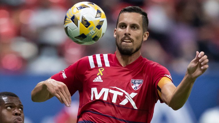 Vancouver Whitecaps' Deiber Caicedo, left, and FC Dallas' Matt Hedges vie for the ball during the second half of an MLS soccer game in Vancouver, on Saturday, September 25, 2021. (Darryl Dyck/CP)