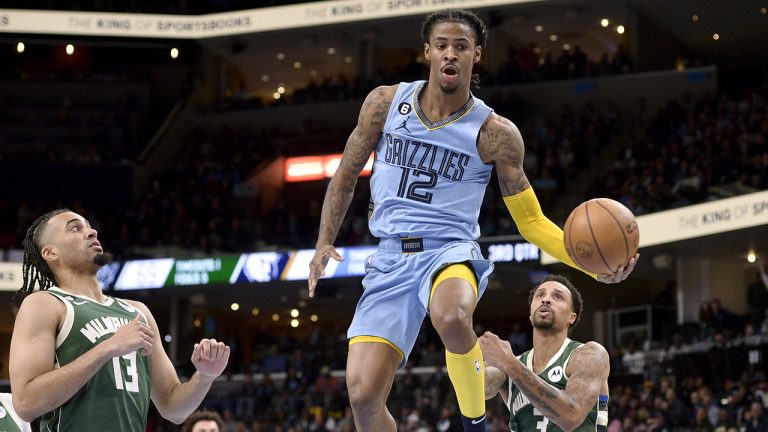 Memphis Grizzlies guard Ja Morant (12) handles the ball between Milwaukee Bucks forward Jordan Nwora (13) and guard George Hill (3) in the second half of an NBA basketball game Thursday, Dec. 15, 2022, in Memphis, Tenn. (Brandon Dill/AP)