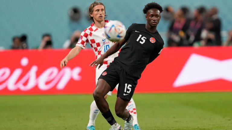 Croatia's Luka Modric, left, passengers the ball past Canada's Ismael Kone during the World Cup group F soccer match between Croatia and Canada, at the Khalifa International Stadium in Doha, Qatar, Sunday, Nov. 27, 2022. (Darko Vojinovic/AP)