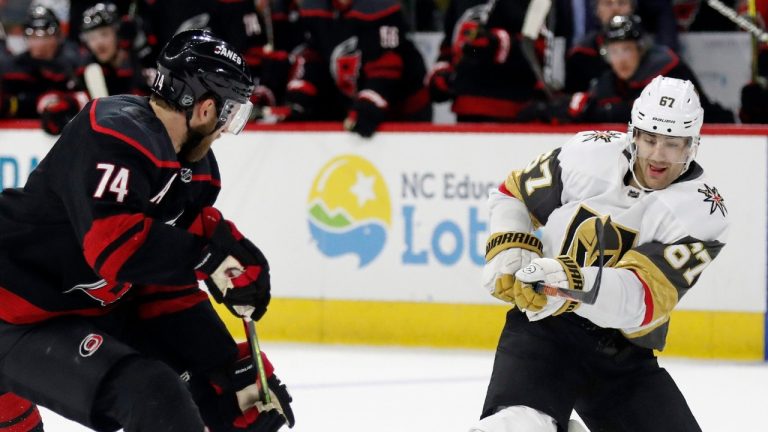 Carolina Hurricanes defenseman Jaccob Slavin (74) chases the puck as Vegas Golden Knights left wing Max Pacioretty (67) goes to the ice during the third period of an NHL hockey game in Raleigh, N.C., Friday, Jan. 31, 2020. (Gerry Broome/AP)
