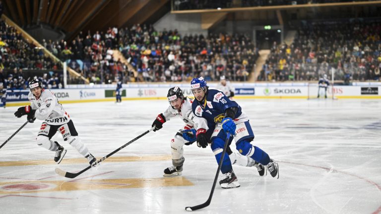 Canada's Nicolas Beaudin, left, fights with Davos' Andres Ambuhl, during the game between Switzerland's HC Davos and Team Canada, at the 94th Spengler Cup ice hockey tournament in Davos, Switzerland, Tuesday, Dec. 27, 2022. (Gian Ehrenzeller/Keystone via AP)