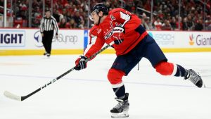 Washington Capitals defenseman John Carlson, right, shoots against Los Angeles Kings center Anze Kopitar (11) during the second period of an NHL hockey game, Saturday, Oct. 22, 2022, in Washington. (Nick Wass/AP)