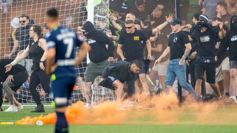 Melbourne Victory fans invade the pitch during the A-League Men's soccer match between Melbourne City and the Melbourne Victory at AAMI Park in Melbourne, Australia Saturday, Dec. 17, 2022. The soccer match between rivals Melbourne City and Melbourne Victory was abandoned Saturday after fans invaded the field and attacked City goalkeeper Tom Glover. (Will Murray/AAP Image via AP)