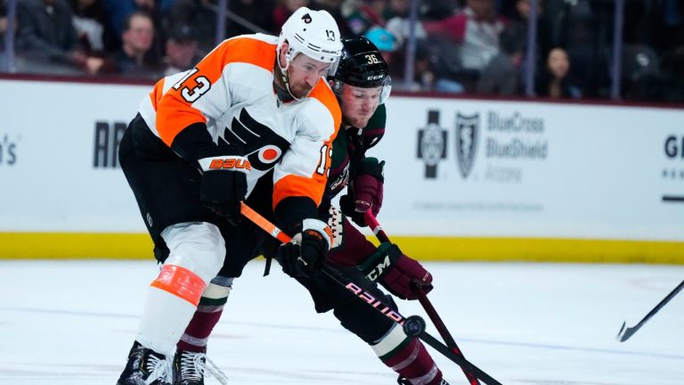 Arizona Coyotes right wing Christian Fischer (36) battles with Philadelphia Flyers center Kevin Hayes (13) for the puck during the first period of an NHL hockey game in Tempe, Ariz., Sunday, Dec. 11, 2022. (Ross D. Franklin/AP)