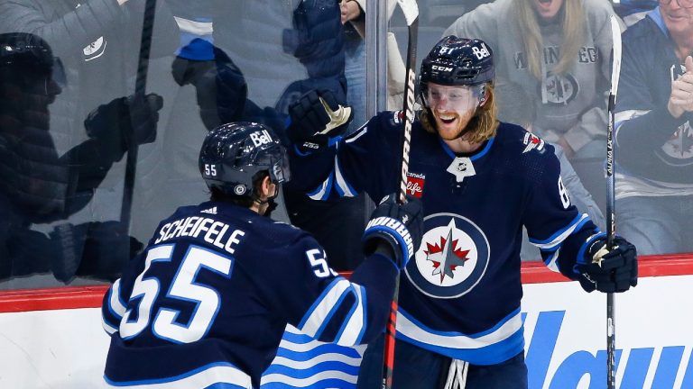 Winnipeg Jets' Mark Scheifele (55) and Kyle Connor (81) celebrate Connor’s game winning goal against Nashville Predators goaltender Juuse Saros in NHL overtime action in Winnipeg, Thursday, December 15, 2022. THE CANADIAN PRESS/John Woods