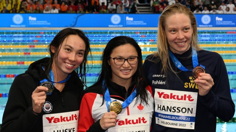 Maggie Mac Neil of Canada, centr,e Torri Huske of the U.S., left, and Louise Hansson of Sweden display their medals after the women's 100m butterfly final during the world swimming short course championships in Melbourne, Australia, Sunday, Dec. 18, 2022. Mac Neil closed out the FINA World Swimming Championships in style on Sunday by setting a world record in the women's 100-metre butterfly. (Asanka Brendon Ratnayake/AP)