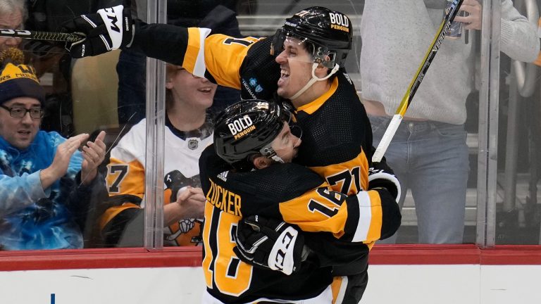 Pittsburgh Penguins' Evgeni Malkin, right, celebrates after his goal with Jason Zucker, center, during the third period of an NHL hockey game against the Dallas Stars in Pittsburgh, Monday, Dec. 12, 2022. (AP Photo/Gene J. Puskar)