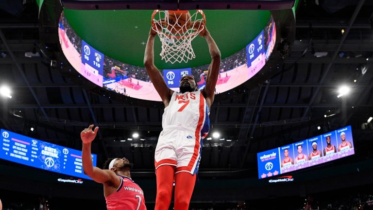 Brooklyn Nets forward Kevin Durant, top, dunks over Washington Wizards guard Jordan Goodwin, second from left, forward Corey Kispert (24) and center Daniel Gafford during the second half of an NBA basketball game, Monday, Dec. 12, 2022, in Washington. The Nets won 112-100. (AP Photo/Nick Wass)