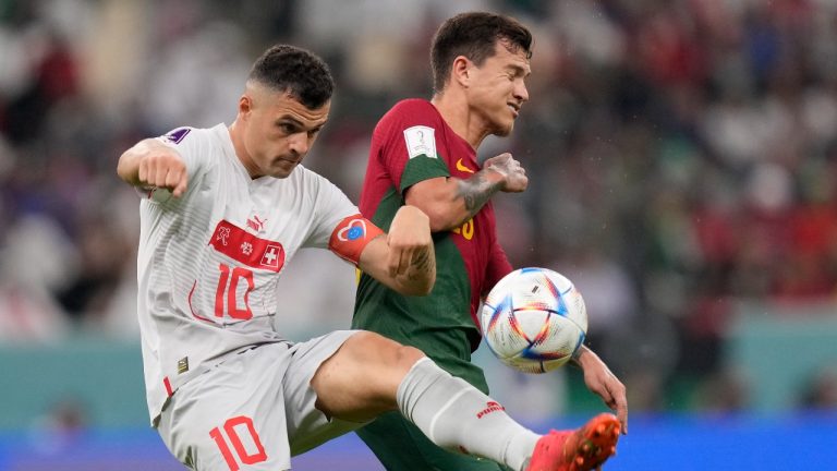 Switzerland's Granit Xhaka, left, and Portugal's Otavio challenge for the ball during the World Cup round of 16 soccer match between Portugal and Switzerland, at the Lusail Stadium in Lusail, Qatar, Tuesday, Dec. 6, 2022. (Darko Bandic/AP Photo)