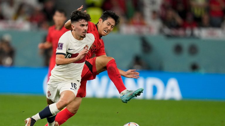 South Korea's Lee Kang-in, right, and Portugal's Vitinha battle for the ball during the World Cup group H soccer match between South Korea and Portugal, at the Education City Stadium in Al Rayyan. (Lee Jin-man/AP)