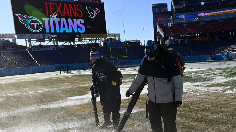 Crews remove tarps that covered the field overnight before an NFL football game between the Tennessee Titans and the Houston Texans, Saturday, Dec. 24, 2022, in Nashville, Tenn. Extreme cold weather has hit the region. (Mark Zaleski/AP Photo)