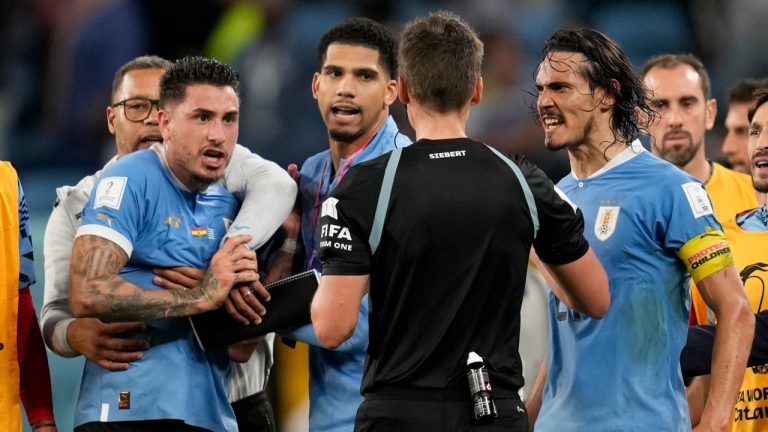 Uruguay's Edinson Cavani right argues with referee Daniel Siebert, of Germany, after hje booked him at the end of a World Cup group H soccer match against Ghana at the Al Janoub Stadium in Al Wakrah, Qatar, Friday, Dec. 2, 2022. (Darko Vojinovic/AP) 