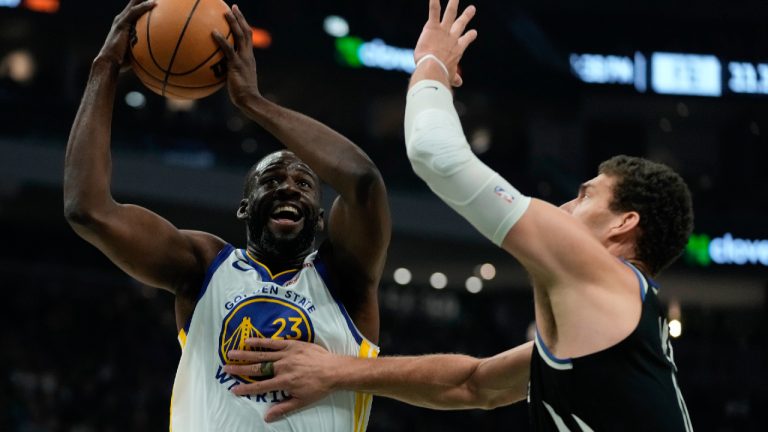Golden State Warriors' Draymond Green shoots past Milwaukee Bucks' Brook Lopez during the first half of an NBA basketball game Tuesday, Dec. 13, 2022, in Milwaukee. (Morry Gash/AP)