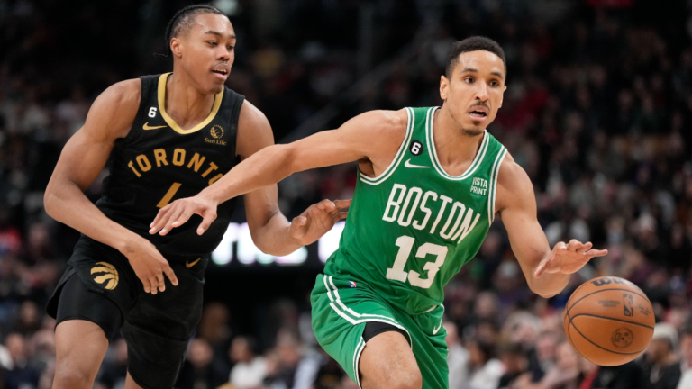 Boston Celtics guard Malcolm Brogdon (13) dribbles away from Toronto Raptors forward Scottie Barnes (4) during second half NBA basketball action in Toronto on Saturday, Jan. 21, 2023. (CP)
