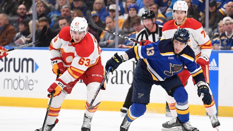 Calgary Flames' Adam Ruzicka (63) controls the puck from St. Louis Blues' Alexey Toropchenko (13) during the first period of an NHL hockey game. (Jeff Le/AP)