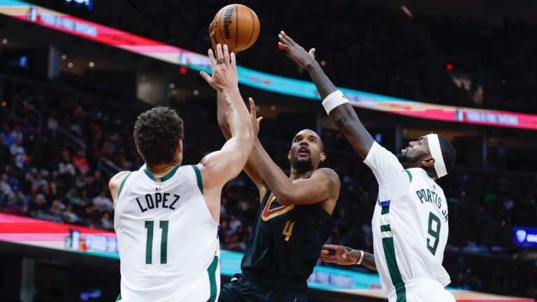 Cleveland Cavaliers forward Evan Mobley (4) shoots against Milwaukee Bucks center Brook Lopez (11) and forward Bobby Portis (9) during the second half of an NBA basketball game, Saturday, Jan. 21, 2023, in Cleveland. (Ron Schwane/AP)