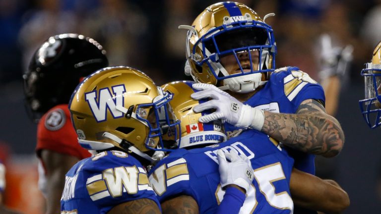 Winnipeg Blue Bombers' Demerio Houston (35), Tyrell Ford (25) and Mike Miller (24) celebrate Ford's game winning tackle against the Ottawa Redblacks during the second half of CFL action in Winnipeg, Friday, June 10, 2022. (John Woods/CP)