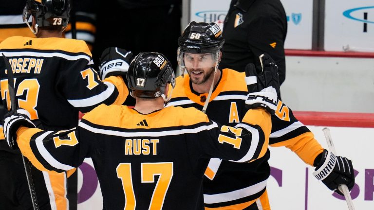 Pittsburgh Penguins' Kris Letang (58) celebrates with Bryan Rust after scoring the game-winning, overtime goal during an NHL hockey game against the Florida Panthers in Pittsburgh, Tuesday, Jan. 24, 2023. The Penguins won 7-6 in overtime. (Gene J. Puskar/AP Photo)