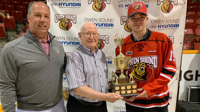 Ray McKelvie, centre, with Attack GM Dale DeGray, left, presenting a team award named for McKelvie to forward Deni Goure in 2019. (Photo courtesy Owen Sound Attack)