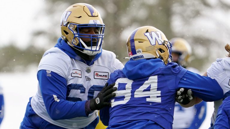 Winnipeg Blue Bombers offensive lineman Stanley Bryant (66) and defensive end Jackson Jeffcoat (94) battle for position during Grey Cup team practice in Regina. (Heywood Yu/CP)