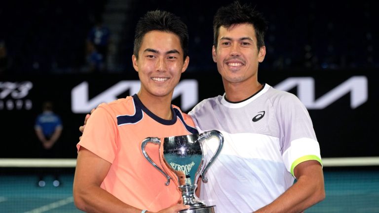 Rinky Hijikata, left, of Australia and compatriot Jason Kubler pose with their winners trophy after defeating Hugo Nys of Monaco and Jan Zielinski of Poland in the men's doubles final at the Australian Open tennis championship in Melbourne, Australia, Sunday, Jan. 29, 2023.. (Aaron Favila/AP)