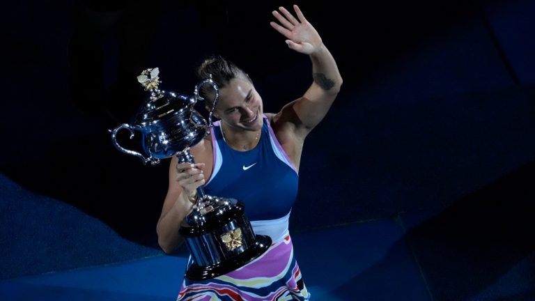 Aryna Sabalenka of Belarus waves as she holds the Daphne Akhurst Memorial Trophy after defeating Elena Rybakina of Kazakhstan in the women's singles final at the Australian Open tennis championship in Melbourne, Australia, Saturday, Jan. 28, 2023. (Ng Han Guan/AP)