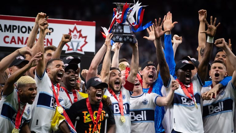 Vancouver Whitecaps' Russell Teibert, centre, hoists the Voyageurs Cup after Vancouver defeated Toronto FC in penalty kicks during the Canadian Championship soccer final, in Vancouver, on Tuesday, July 26, 2022. (Darryl Dyck/CP)