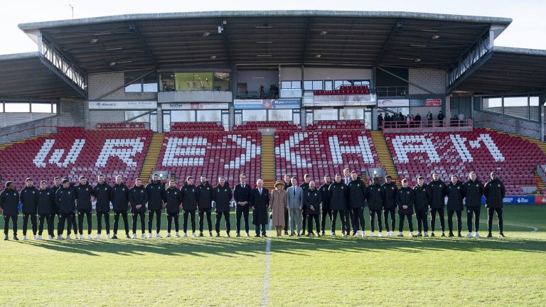Britain's King Charles III and Camilla, the Queen Consort meet Wrexham Soccer team co owners, US actors Ryan Reynolds and Rob McElhenney and players during their visit to Wrexham Association Football Club's Racecourse Ground, in Wrexham, England, Friday, Dec. 9, 2022. (Arthur Edwards/Pool Photo via AP)