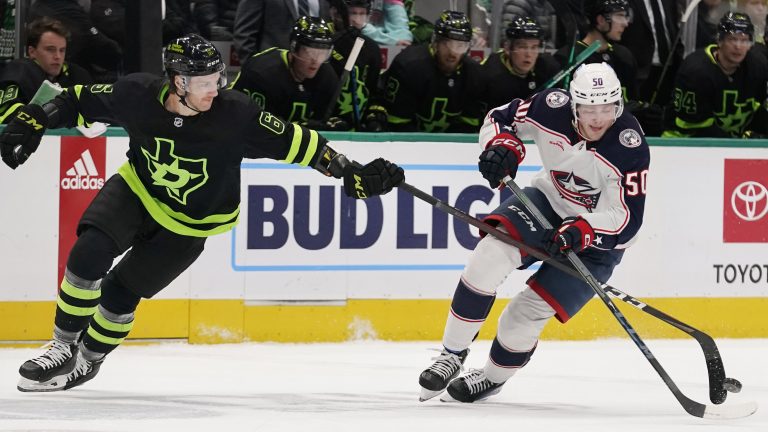Columbus Blue Jackets left wing Eric Robinson skates with the puck as Dallas Stars defenseman Colin Miller  reaches for it during the second period of an NHL hockey game in Dallas, Saturday, Feb. 18, 2023. (LM Otero/AP)