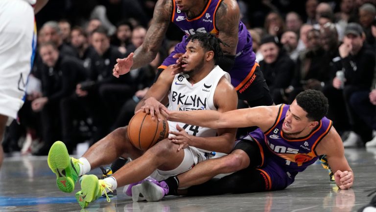 Brooklyn Nets guard Cam Thomas (24) fights for a loose ball against Phoenix Suns guard Devin Booker, bottom, and forward Torrey Craig during the second half of an NBA basketball game, Tuesday, Feb. 7, 2023, in New York. The Suns won 116-112. (Mary Altaffer/AP)