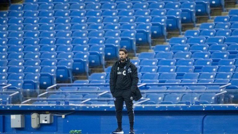 CF Montreal head coach Hernan Losada stands on a barrier to look over a practice during the first day of training camp in Montreal on Monday, January 9, 2023. (Paul Chiasson/The Canadian Press)