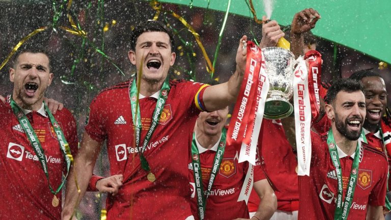 Manchester United's Bruno Fernandes, centre right, and Harry Maguire, second from left, hold the trophy during celebration as they won the English League Cup final soccer match between Manchester United and Newcastle United at Wembley Stadium in London, Sunday, Feb. 26, 2023. (Alastair Grant/AP)