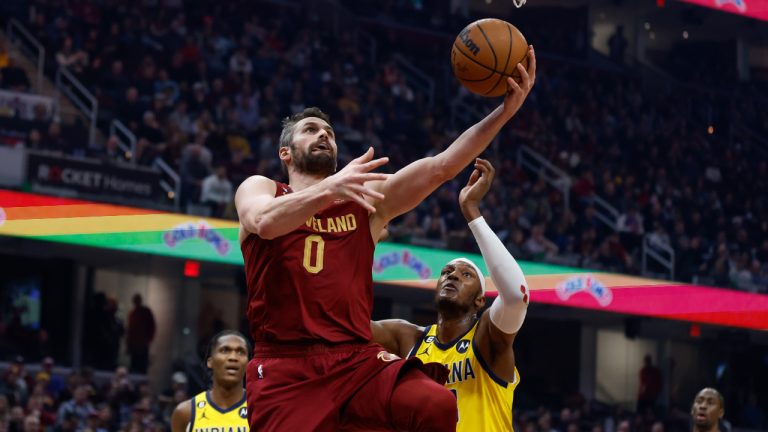 Cleveland Cavaliers forward Kevin Love (0) shoots against Indiana Pacers center Myles Turner and guard Bennedict Mathurin (00) during the first half of an NBA basketball game, Friday, Dec. 16, 2022, in Cleveland. (Ron Schwane/AP)
