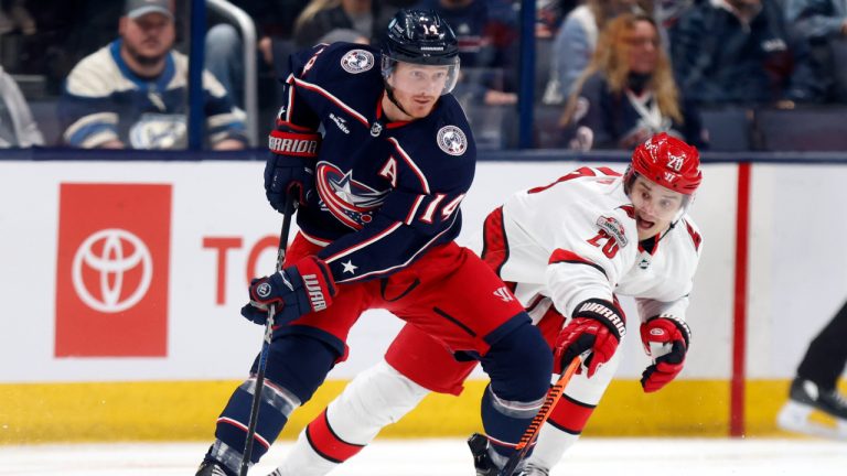 Columbus Blue Jackets forward Gustav Nyquist, left, controls the puck next to Carolina Hurricanes forward Sebastian Aho during the first period of an NHL hockey game. (Paul Vernon/AP)