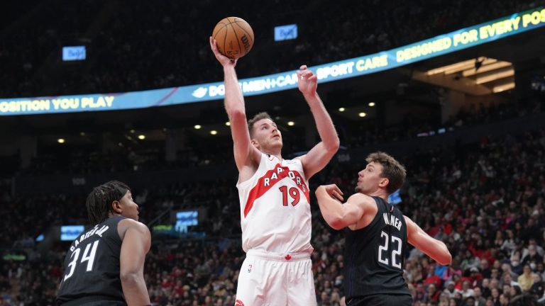 Toronto Raptors Jakob Poeltl scores on Orlando Magic's Wendell Carter Jr. and Franz Wagner during first half NBA basketball action in Toronto on Tuesday, February 14, 2023. (Chris Young/The Canadian Press)