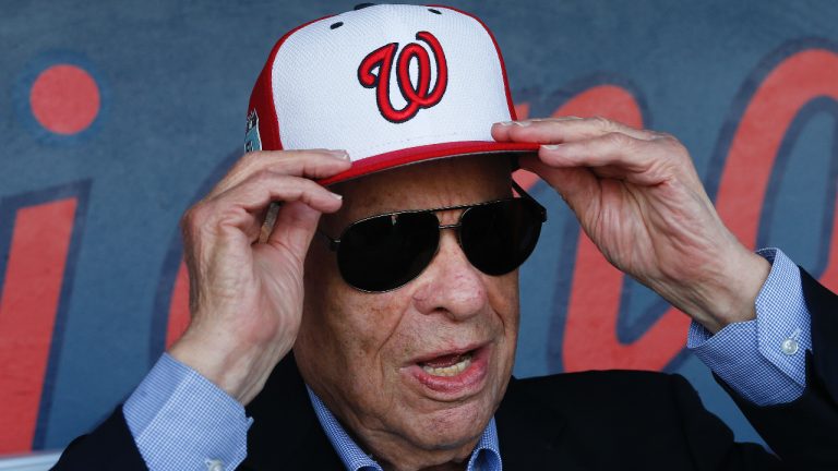 Washington Nationals owner Ted Lerner tries on a baseball cap before a ribbon cutting ceremony to open The Ballpark in West Palm Beach, Fla. Washington Nationals founder Ted Lerner has died. He was 97. Lerner bought the team from Major League Baseball in 2006 for $450 million. He was managing principal owner until ceding that role to son Mark in 2018. (John Bazemore/AP)