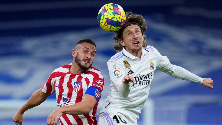 Real Madrid's Luka Modric, right, heads the ball past Atletico Madrid's Koke during a Spanish La Liga soccer match between Real Madrid and Atletico Madrid at the Santiago Bernabeu stadium in Madrid, Spain, Saturday, Feb. 25, 2023. (Manu Fernandez/AP)
